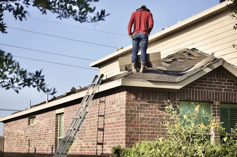 Professional roofer working on a residential roof in Gotts